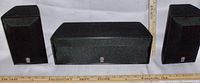 Front view showing two bookshelf satellite speakers and one center channel speaker with Yamaha logos.