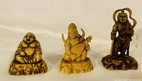 Photo showing all three figurines lined up on a flat surface against white background