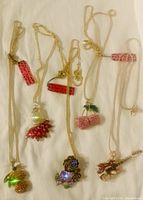Five Betsey Johnson necklaces with unique crystal-adorned pendants: pineapple, tropical fruit, cherries, floral cluster, and guitar pendant.