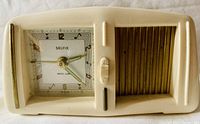 Front view of cream vintage Selfix musical alarm clock showing clock face, speaker grille, and alarm switch.