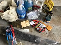 Overview of entire lot showing fluids, cables, accessories laid out on concrete floor