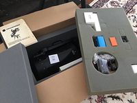 Open foam case showing telescope tube nestled in foam alongside accessories tray and instruction manual