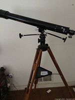 Side view of the full telescope mounted on wooden tripod with accessory tray.