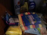 Photo showing assorted cleaning sponges, Lysol spray bottles and power cleaner, Minwax cleaner, various wipes and pads.