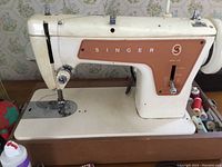 Cream and brown vintage Singer sewing machine on wooden table