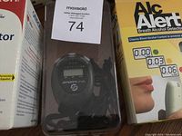 Photo showing boxed Sportline stopwatch and ALCalert breath alcohol detector side by side