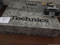 Original packaging for Technics SL-BD20D turntable system showing brand and model information on textured gray box.