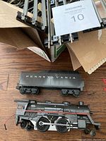 Close-up photo of vintage Pennsylvania model train engine and tender with visible details and wear.