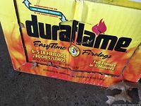 Photo showing close-up of Duraflame Easy Time Firelogs packaging indicating 6.5 lb firelogs, full flames in 5 minutes, low emission product, and other product details.