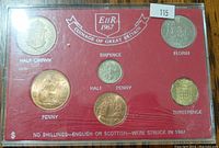 Front view of the coin set showing six coins with denomination names and a label, encased in hard plastic with red background insert.