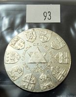 Obverse side showing central star with '1867 CANADA CENTENNIAL 100 YEARS' text surrounded by ten shield emblems.