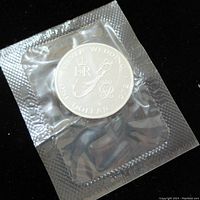 Front of the coin showing the commemorative Silver Wedding design, sealed in clear plastic packaging.