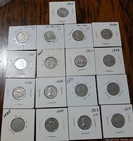Photo of lot showing all 17 Canadian 5 cents coins in protective sleeves on table.