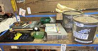 Wide view of fishing gear including two Minnow Buckets, soft plastic lures, hooks, tackle boxes and floats on tables.