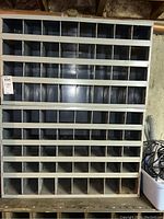 Front view of metal storage cubby showing multiple compartments and overall rectangular shape.