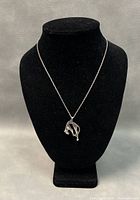 Necklace displayed on a black mannequin bust to show pendant and chain length.