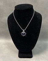 Choker necklace displayed on black stand showing chain and blue heart-shaped crystal pendant.