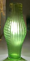 Green translucent uranium glass vase by Wilhelm Kralik showing honeycomb texture with light shining through to reveal characteristic uranium glow.