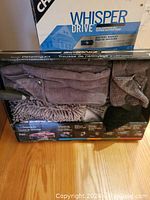 Original Chamberlain Whisper Drive opener box standing upright on hardwood floor