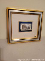 Full view of the framed 3D artwork showing the Roman Colosseum with gold and silver leaf in a white and gold frame.