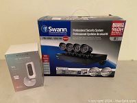 Swann Pro-Series 960H system box alongside Smanos IP6 camera box on surface