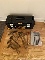 Full view of DEWALT tool box with hammers, axes, and hand file set arranged on wood floor