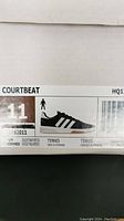 Close-up of shoe size label on box showing US size 11, model Courtbeat, men's tennis shoe.