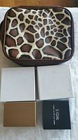 Closed leopard print jewellery pouch and four small boxes of jewelry