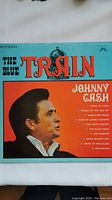 Album cover of Johnny Cash 'The Blue Train' with track listing visible.