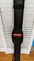 Black pool cue case with Budweiser logo on small zippered pouch on front.