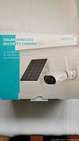 Front of the box showing the Dekco brand solar wireless security camera with motion-activated alarm and solar power built-in battery features.