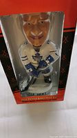 Front view of the Tie Domi bobblehead in packaging showing the figure and branding.