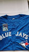 Folded blue Toronto Blue Jays jersey with 'Blue Jays' text and team logo on the front, Topps Platinum card placed on the jersey.
