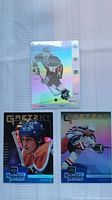 Three Wayne Gretzky hockey cards showing holographic finishes and various playing action poses.