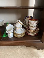 Overview of assorted cups and saucers inside cabinet