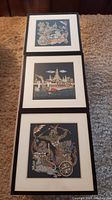Three framed wall arts showing Asian-themed prints with detailed characters and scenes on black backgrounds.