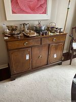 Front view of the wooden hutch showing two drawers and three door cabinets with brass hardware and a polished wood finish.