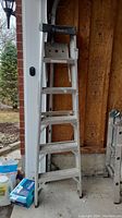 Full view of Featherlite aluminum step ladder in garage area, showing height and overall condition.