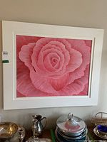 Full view of framed wall art depicting a detailed pink rose in shades of pink, white frame and white matting.
