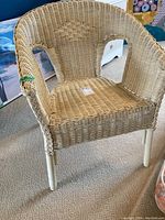 Front view of vintage wicker chair with woven design and white legs
