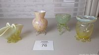 Four small glass items displayed on countertop with lot number card