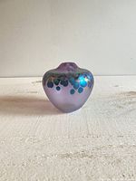 Front view of rounded purple matte-finished handblown glass vase with blue-green iridescent spots.