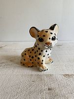 Front view of the hand painted ceramic cheetah cub figurine planter showing facial details and spotted body.