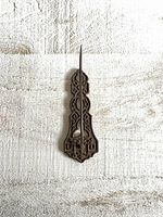 Front view of ornate Victorian style metal wall-mounted spike holder showing intricate backplate design and central spike.