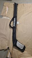Full view of the Bauer hockey stick bag placed flat showing its long shape and padded strap.