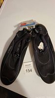 Pair of black Speedo water shoes with tags on white background.