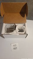 Box opened showing two clear glasses packed inside with protective tissue.