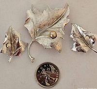 Full set with brooch, earrings, and a Canadian quarter showing scale.