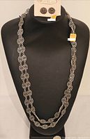 Front view of necklace displayed on bust with stud earrings on original D'ORLAN card.