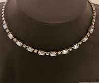 Front view of vintage Weiss necklace displayed on black bust showing rectangular and round crystals set in silver-tone metal.